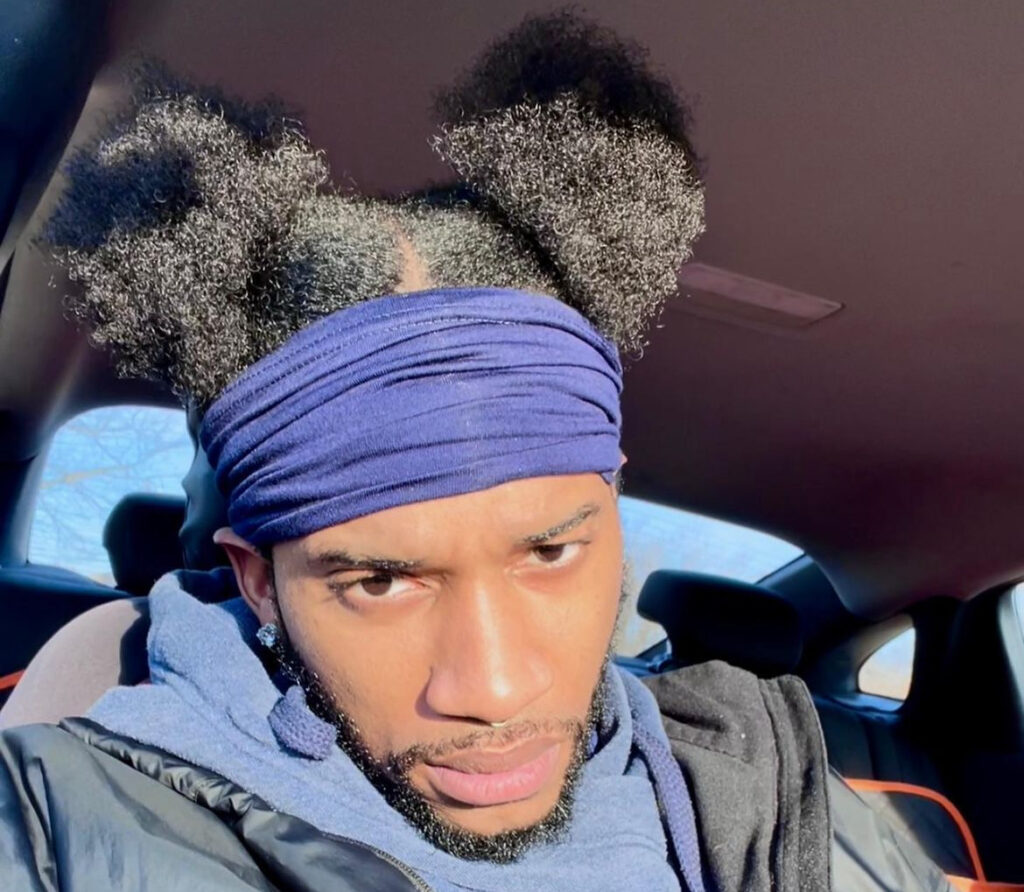 Photo of JaQ Lee, a TikTok teacher, sitting in his car showing his hair.