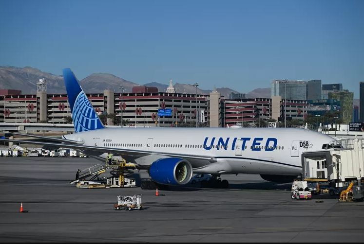 United Airlines plane awaiting passengers at the gate, set against the backdrop of Las Vegas’s striking skyline. Photo Credit: Artur Widak / NurPhoto via Getty Images