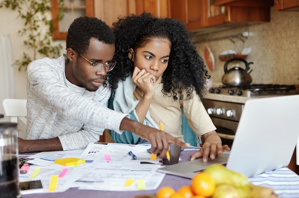 Young couple looking over their finances. Photo: Cast Of Thousands/Shutterstock